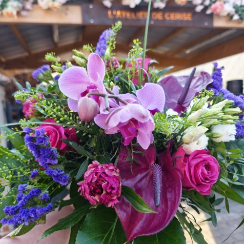Bouquet de fleurs coupées, composé d'orchidée, de zantedeschia, roses, pivoine, statice, lisianthus et feuillages.