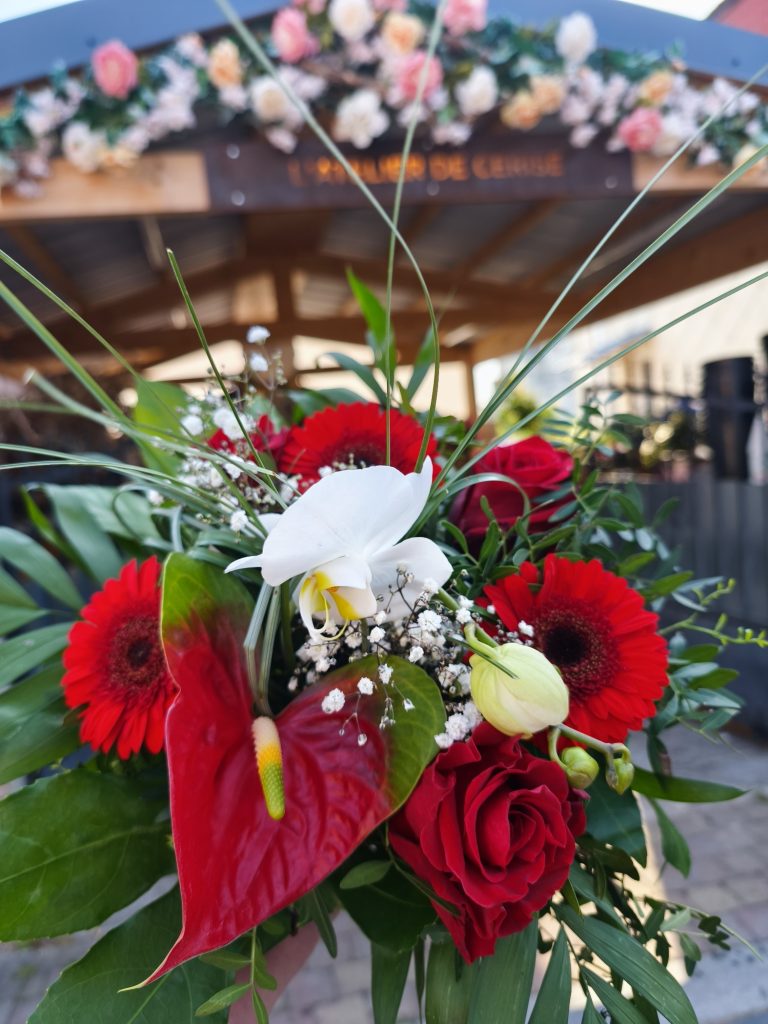 Bouquet de fleurs coupées, composé d'orchidée, roses, zantedeschia, germinis, gypsophile et feuillages.