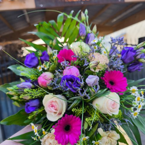 Bouquet de fleurs coupées, composé de roses, lisianthus, germinis, oeillets, camomille et feuilages.