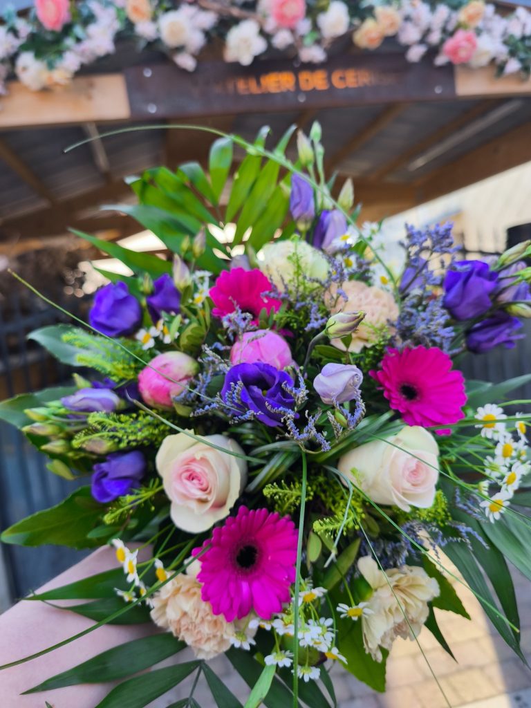 Bouquet de fleurs coupées, composé de roses, lisianthus, germinis, oeillets, camomille et feuilages.